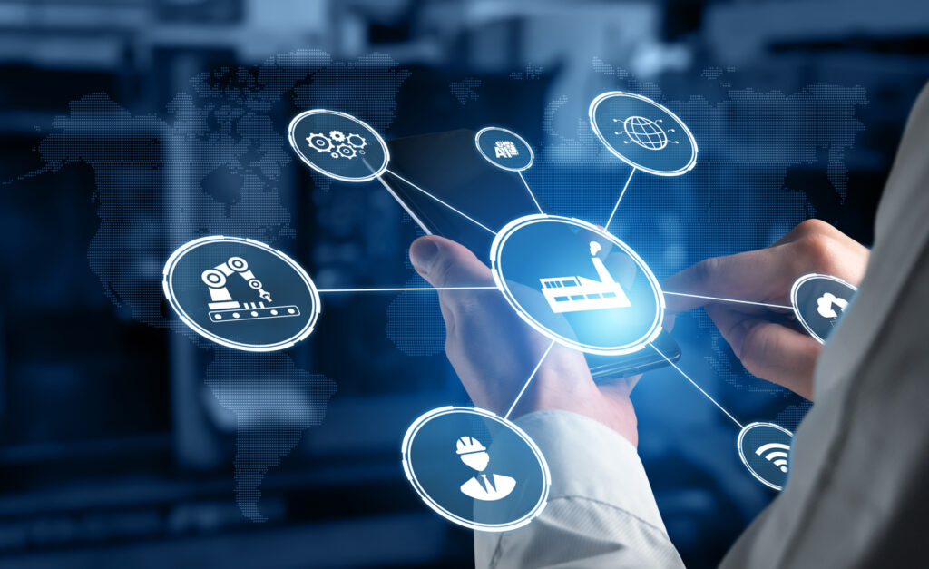 Industry 4.0 heavily involves the Internet of Things. This image represents how via a mobile device, IoT technology allows a warehouse manager to remotely control robots, communicate with personnel, access inventory stored in the cloud, etc.