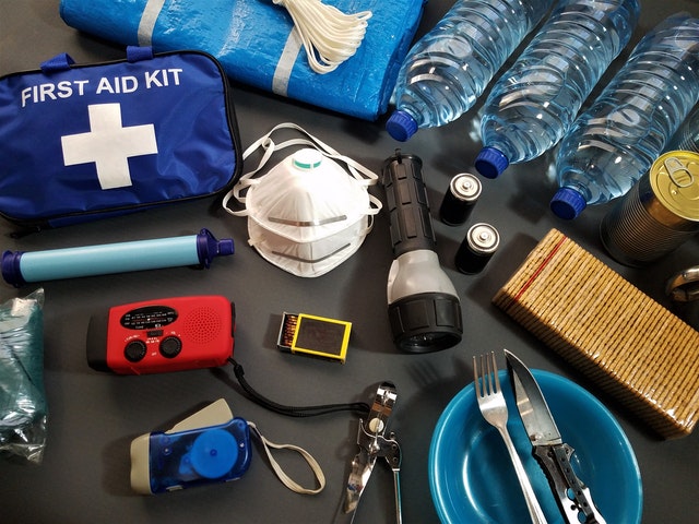 emergency first aid kit supplies, including masks, water, flashlight